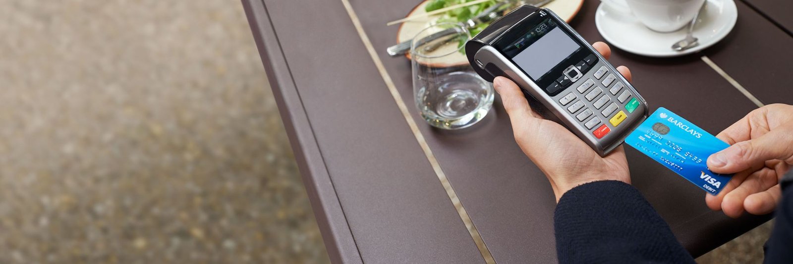 A Barclays Visa Debit card being inserted into a card reader at a restaurant
